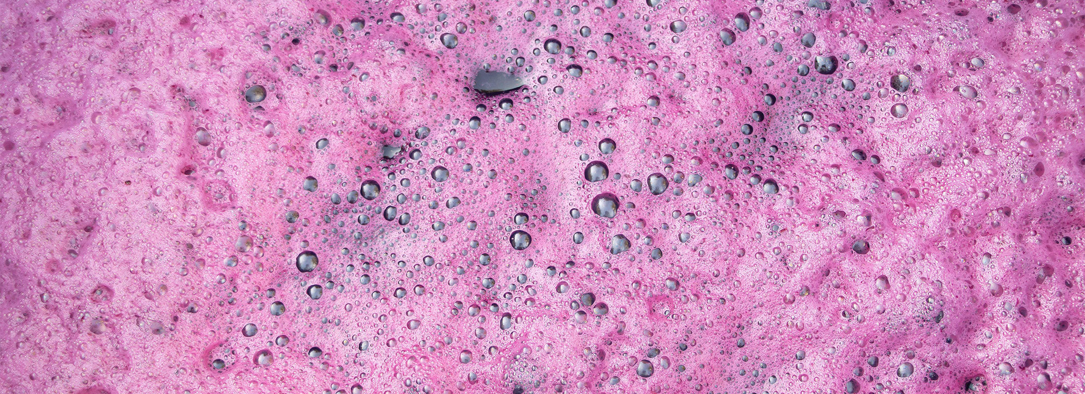 Closeup of wine in full ferment with pink foam